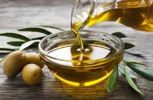 Aceite de oliva Aceite de oliva virgen en un recipiente, líquido para la masa y engrase del molde de fainá.