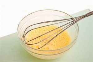 Huevo batido Huevo batido con varillas, ligamento clave para la masa de pan de queso almojábanas.