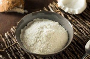Harina de coco Harina de coco en polvo, ingrediente bajo en carbohidratos, en un bol de mezcla.
