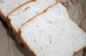 Rebanadas de pan de molde blanco, listas para untar con la mezcla.