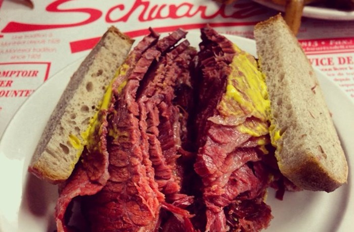 Sándwich de Pastrami estilo Nueva York en pan de centeno, alta pila de carne, mostaza y pepinillos